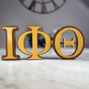 Letras de pie Iota Phi Theta. Decoración marrón y dorada para colgar en la pared, escritorio, estantería o sobremesa. Regalo para miembros o capítulos.