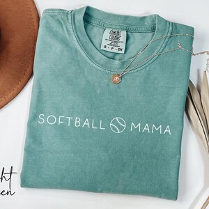May include: A light green t-shirt with the text "SOFTBALL MAMA" and a baseball graphic in white.