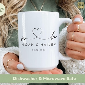 May include: A white 15oz mug with a black heart and the names "Noah & Hailey" and the date "06.12.2026" printed on it. The mug is labeled "Dishwasher & Microwave Safe".