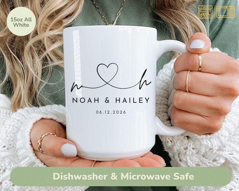 May include: A white 15oz mug with a black heart and the names "Noah & Hailey" and the date "06.12.2026" printed on it. The mug is labeled "Dishwasher & Microwave Safe".