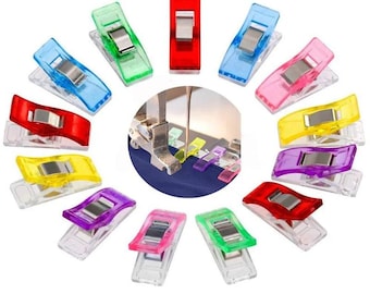 May include: Assortment of colorful plastic clips for sewing projects. The clips are transparent with a metal spring and come in red, blue, green, yellow, purple, and pink.