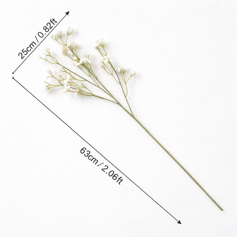 K&ouml;nnte beinhalten: Ein einzelner k&uuml;nstlicher Blumenstiel mit kleinen wei&szlig;en Bl&uuml;ten und gr&uuml;nen Stielen. Der Stiel ist 63 cm lang, der Bl&uuml;tenteil misst 25 cm. Die Blume ist vor einem wei&szlig;en Hintergrund platziert.