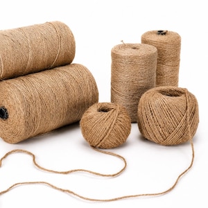May include: A collection of natural brown twine in various forms: large spools and smaller balls. The twine is tightly wound, with a few spools cylindrical and others spherical. A length of twine trails from one of the balls.