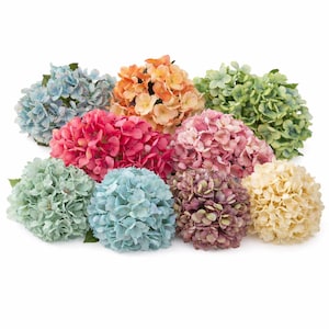 Pode incluir: Uma coleção de buquês de flores de hortênsia artificiais em várias cores, incluindo azul, rosa, laranja, verde e creme. Cada buquê apresenta um grupo denso de pequenas pétalas texturizadas, com folhas verdes na base.