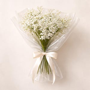 K&ouml;nnte beinhalten: Ein Bouquet aus wei&szlig;en Schleierkrautbl&uuml;ten, verpackt in durchsichtigem Zellophan. Die Stiele sind mit einem cremefarbenen Satinband gebunden, was eine zarte und elegante Pr&auml;sentation ergibt. Die Bl&uuml;ten haben eine weiche wei&szlig;e Farbe.