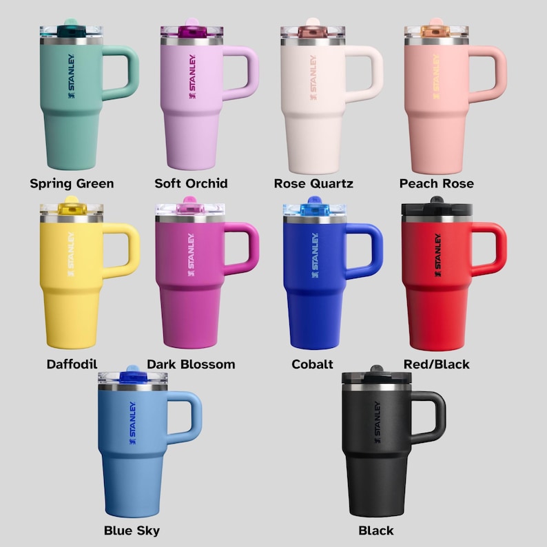 May include: A collection of Stanley insulated mugs in various colors, including Spring Green, Soft Orchid, Rose Quartz, Peach Rose, Daffodil, Dark Blossom, Cobalt, Red/Black, Blue Sky, and Black. Each mug has a handle and a lid.