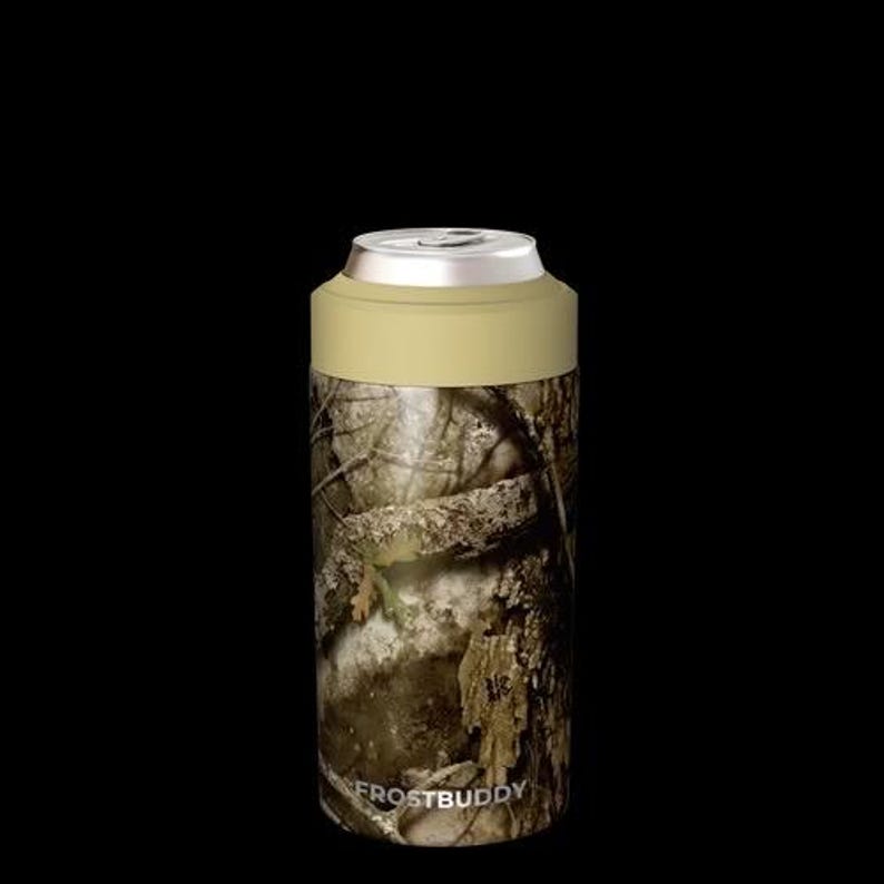 Puede incluir: Un enfriador de latas cil&iacute;ndrico con un patr&oacute;n de camuflaje forestal realista en tonos marrones, verdes y grises. El borde superior es de un color beige claro s&oacute;lido y la palabra FROSTBUDDY est&aacute; impresa en letras blancas cerca de la base.