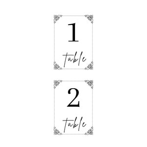May include: Two black and white table number cards with ornate frames. The top card has the number 1 and the text "table" below. The bottom card has the number 2 and the text "table" below.