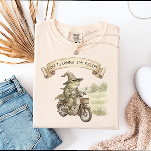 Peut inclure: Une tasse en céramique blanche avec une anse noire et le texte "But First, Coffee" dans un style manuscrit. La tasse est posée sur une surface blanche. La tasse mesure 10 cm de haut.