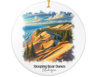 Puede incluir: Adorno navideño redondo de cerámica blanca con un paisaje de Sleeping Bear Dunes, Michigan. La imagen muestra dunas de arena, un lago azul y un cielo brillante. Tiene una cuerda dorada para colgar.
