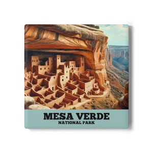 May include: A square canvas print featuring Mesa Verde National Park. The image shows ancient cliff dwellings nestled under a large rock overhang. The print has a teal border with the words "MESA VERDE NATIONAL PARK" in bold, black text.