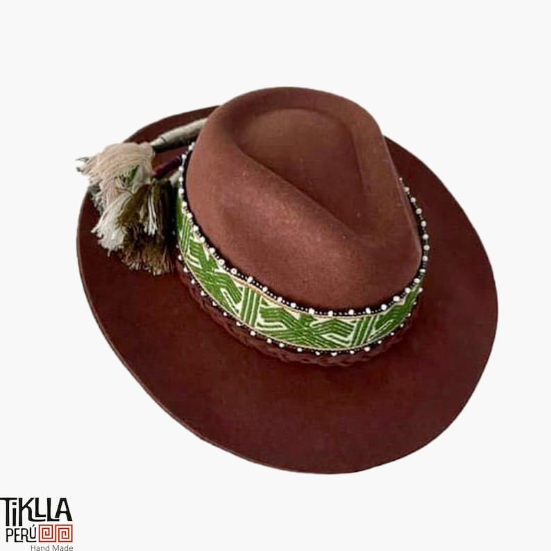 May include: A brown felt fedora hat with a green and white patterned band and a brown tassel. The band is decorated with white beads.
