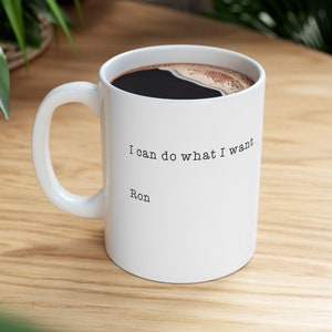 May include: White ceramic coffee mug with a black handle. The mug has black text that reads "I can do what I want. Ron"