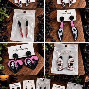 May include: A collection of horror-themed dangle earrings featuring various designs including knives with ghost-like masks, blood-splattered blades, and clown faces. Some earrings are heart-shaped, while others are long knife pendants on silver hooks.