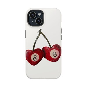 May include: A white iPhone case with a design of two red cherries. Each cherry has a white number "8" on it, resembling a pool ball.