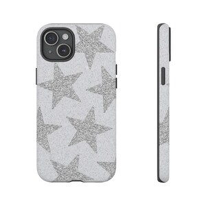 Pode incluir: Uma capa de telefone branca com um padrão de estrelas de glitter prateadas.