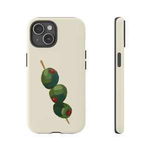 Pode incluir: Uma capa branca para iPhone com um design de espeto de azeitonas verdes. A capa tem uma protuberância da câmera preta e uma borda preta.