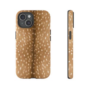 Pode incluir: Uma capa de telefone com um padrão de manchas castanhas e brancas, que lembra o pelo de um veado. A capa tem uma borda preta e um recorte para a câmara. A vista lateral mostra a espessura e a colocação dos botões. Um acessório único e elegante.