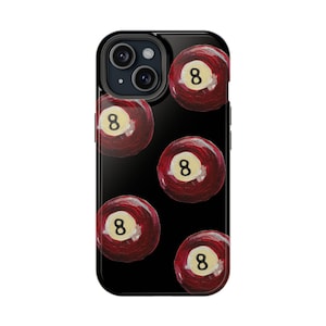 Pode incluir: Capa de telefone preta com um padrão de bolas de bilhar vermelhas número 8. A capa do telefone tem um recorte para a câmera e uma borda preta.