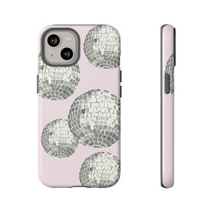 Pode incluir: Uma capa de telefone rosa com um padrão de bolas de discoteca pretas e brancas. A capa é projetada para um iPhone.