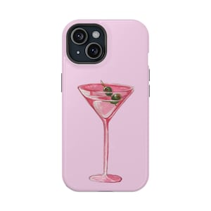 May include: Pink phone case featuring a watercolor illustration of a pink martini glass with two green olives. The martini glass is filled with a pink liquid and has a long stem. The phone case has a glossy finish.