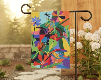 May include: A colorful garden flag with a geometric design featuring ants, flowers, and leaves. The flag is attached to a black metal stand.