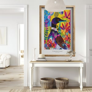 Pode incluir: Uma impress&atilde;o art&iacute;stica emoldurada com uma ilustra&ccedil;&atilde;o colorida de um Mobelha-grande. A obra de arte apresenta um design geom&eacute;trico com tons vibrantes de azul, roxo, amarelo e vermelho, rodeado por elementos florais. A impress&atilde;o &eacute; exibida numa mesa branca com duas cestas de vime.