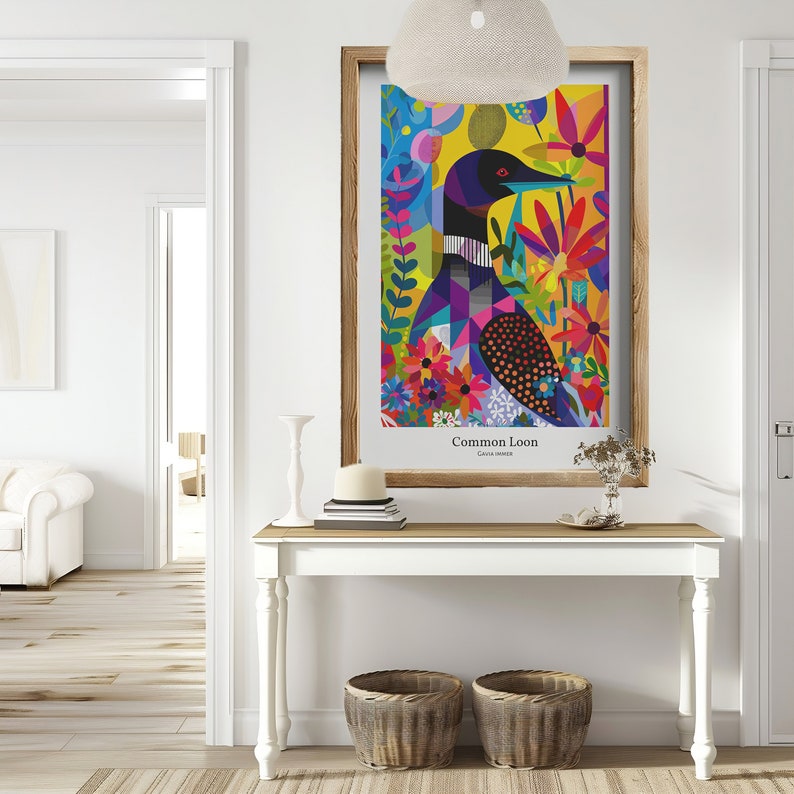 Pode incluir: Uma impress&atilde;o art&iacute;stica emoldurada com uma ilustra&ccedil;&atilde;o colorida de um Mobelha-grande. A obra de arte apresenta um design geom&eacute;trico com tons vibrantes de azul, roxo, amarelo e vermelho, rodeado por elementos florais. A impress&atilde;o &eacute; exibida numa mesa branca com duas cestas de vime.