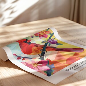 May include: A geometric illustration of a Northern Cardinal perched on a branch with pink blossoms. The bird is red, orange, and yellow, and the background is a light blue and yellow.