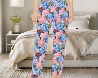 Puede incluir: Pantalones de pijama con un vibrante estampado floral de hortensias azules y rosas. Los pantalones de pijama están hechos de un material suave y tienen un ajuste relajado. Los pantalones son adecuados para descansar o dormir.