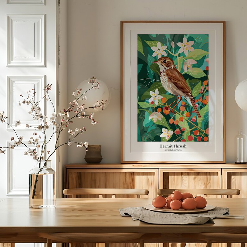 May include: A framed art print featuring a Hermit Thrush bird illustration. The artwork showcases a brown bird perched on a branch with white flowers and orange berries against a green background. The print includes the text "Hermit Thrush" and "Catharus guttatus".