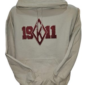 May include: A light gray hooded sweatshirt with a maroon diamond-shaped logo featuring the text "19K11".
