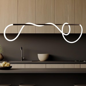 May include: A modern kitchen island with a dark brown countertop and three black bar stools. A white, curved pendant light hangs above the island.