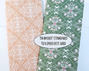 May include: Two rectangular notebook inserts with rounded corners. The left insert is peach with a white geometric pattern. The right insert is green with a white and pink floral pattern. Text reads: TN INSERT STANDARD TEA DYED DOT GRID.