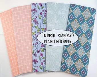 May include: Five tall, rectangular paper notebook inserts featuring various patterns: peach grid, pink floral, light blue geometric, and teal diamond tile. The center text reads: TN INSERT STANDARD PLAIN LINED PAPER.