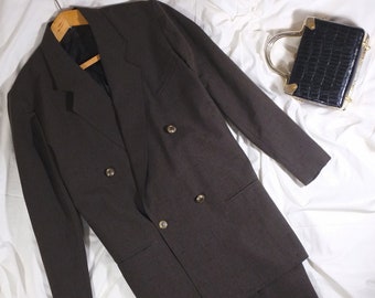 May include: A brown double-breasted blazer with a matching skirt, two pairs of orange heeled shoes, and a small black crocodile-embossed handbag with a gold handle.