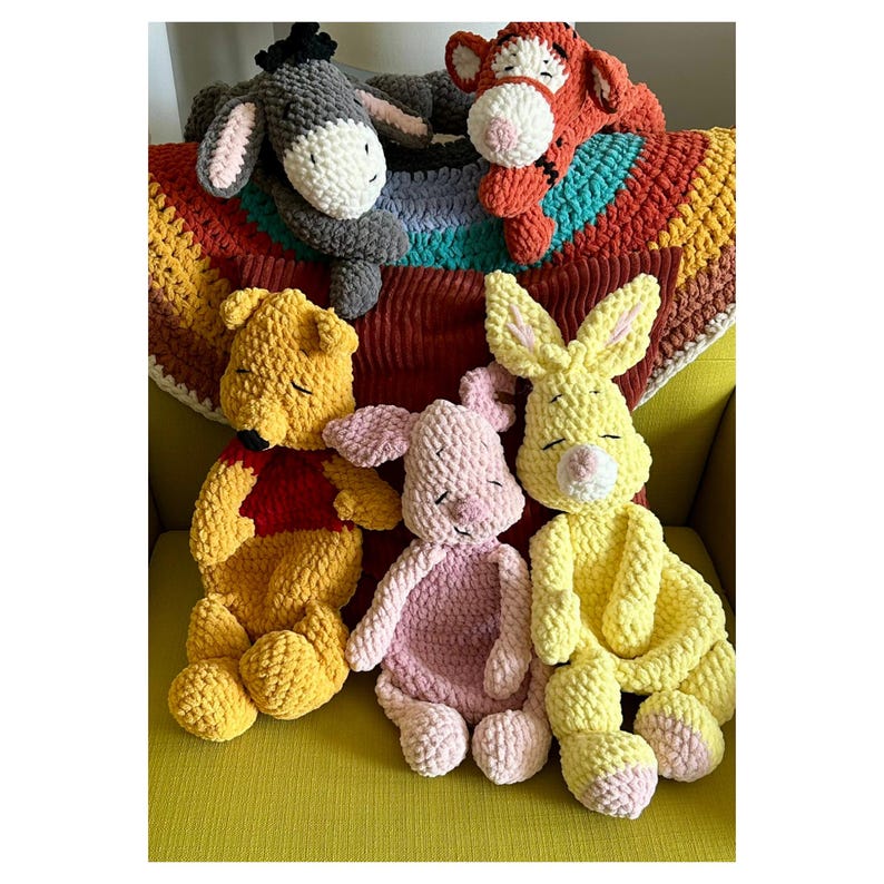 Puede incluir: Colecci&oacute;n de peluches hechos a mano con personajes de un popular libro infantil. Los juguetes incluyen un oso amarillo, un cerdo rosa, un conejo amarillo, un burro gris y un tigre naranja. Est&aacute;n colocados sobre una manta colorida.
