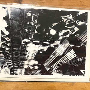 May include: Black and white photograph of a ceiling with many circular lights and a striped pattern.