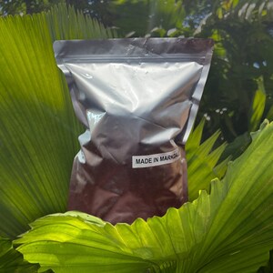 K&ouml;nnte beinhalten: Ein silberner Folienbeutel gef&uuml;llt mit einer dunkelbraunen Substanz. Der Beutel hat ein wei&szlig;es Etikett mit der Aufschrift "MADE IN MARKDALE".