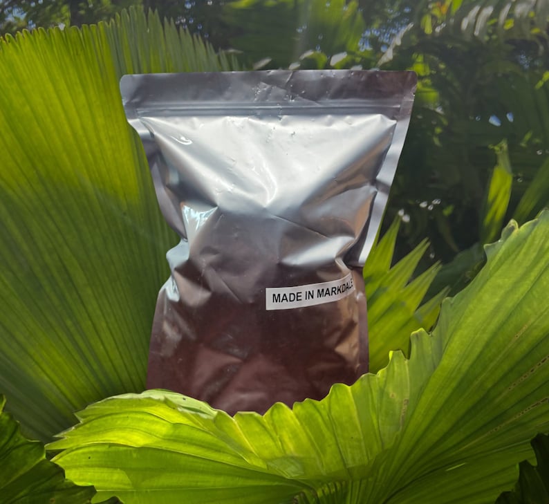 K&ouml;nnte beinhalten: Ein silberner Folienbeutel gef&uuml;llt mit einer dunkelbraunen Substanz. Der Beutel hat ein wei&szlig;es Etikett mit der Aufschrift "MADE IN MARKDALE".