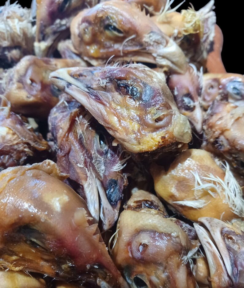 K&ouml;nnte beinhalten: Nahaufnahme eines Stapels getrockneter H&uuml;hnerk&ouml;pfe. Die K&ouml;pfe sind braun und haben eine leicht gummiartige Textur. Sie sind eine beliebte Zutat in einigen asiatischen K&uuml;chen.