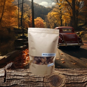 K&ouml;nnte beinhalten: Ein brauner Papierbeutel mit einem durchsichtigen Fenster, in dem getrocknete Pilze zu sehen sind. Auf dem Beutel steht der Text "MADE IN MARKDALE". Der Beutel liegt auf einem Holzstamm vor einem malerischen Herbstwald.