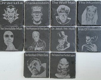 May include: Set of ten black slate coasters featuring classic Universal Monsters characters. Each coaster has a different character, including Dracula, Frankenstein, The Wolf Man, The Mummy, The Invisible Man, The Phantom of the Opera, Dr. Jekyll/Mr. Hyde, Bride of Frankenstein, The Hunchback of Notre Dame, and The Creature from the Black Lagoon.
