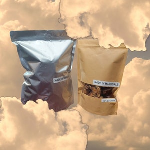 K&ouml;nnte beinhalten: Zwei Beutel mit dehydriertem Essen, einer silberfarben und einer braun. Der silberne Beutel hat ein Etikett mit der Aufschrift "Made in Markdale". Der braune Beutel hat ein Etikett mit der Aufschrift "Made in Markdale" und "100 % Dehydriert".