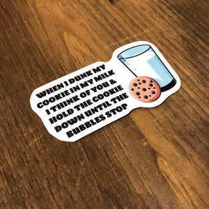 May include: White sticker with black text that reads "WHEN I DUNK MY COOKIE IN MY MILK I THINK OF YOU & HOLD THE COOKIE DOWN UNTIL THE BUBBLES STOP". A cartoon glass of milk and a chocolate chip cookie are pictured on the sticker.