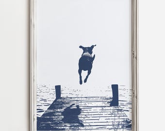 Può includere: Una stampa incorniciata con una silhouette blu navy di un cane che salta da un molo di legno in acqua. L'ombra del cane è proiettata sul molo. La stampa ha uno sfondo bianco e una cornice in legno grigio.