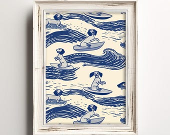 Puede incluir: Una impresión enmarcada con un patrón repetido de perros salchicha surfeando en tablas de surf azules en medio de olas azules sobre un fondo crema. La impresión está en un marco de madera blanco envejecido. Los perros están representados en un estilo de dibujos animados.