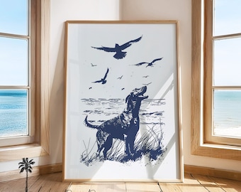 May include: Framed art print featuring a navy blue illustration of a dog barking at birds flying over the ocean. The artwork is set against a white background, framed in a light wood. The scene evokes a coastal theme.