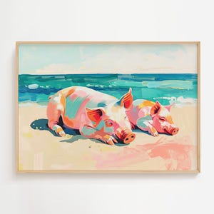 May include: A framed art print depicts two pigs relaxing on a beach. The pigs are painted in shades of pink, orange, and teal, with the ocean and sky in the background. The artwork has a whimsical, colorful style.