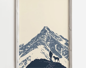 May include: A framed print of a mountain range with a person and a dog standing on a peak. The mountain is a dark blue colour and the background is a light beige.